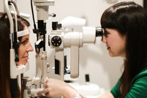 Two people using optometry equipment in an appointment 