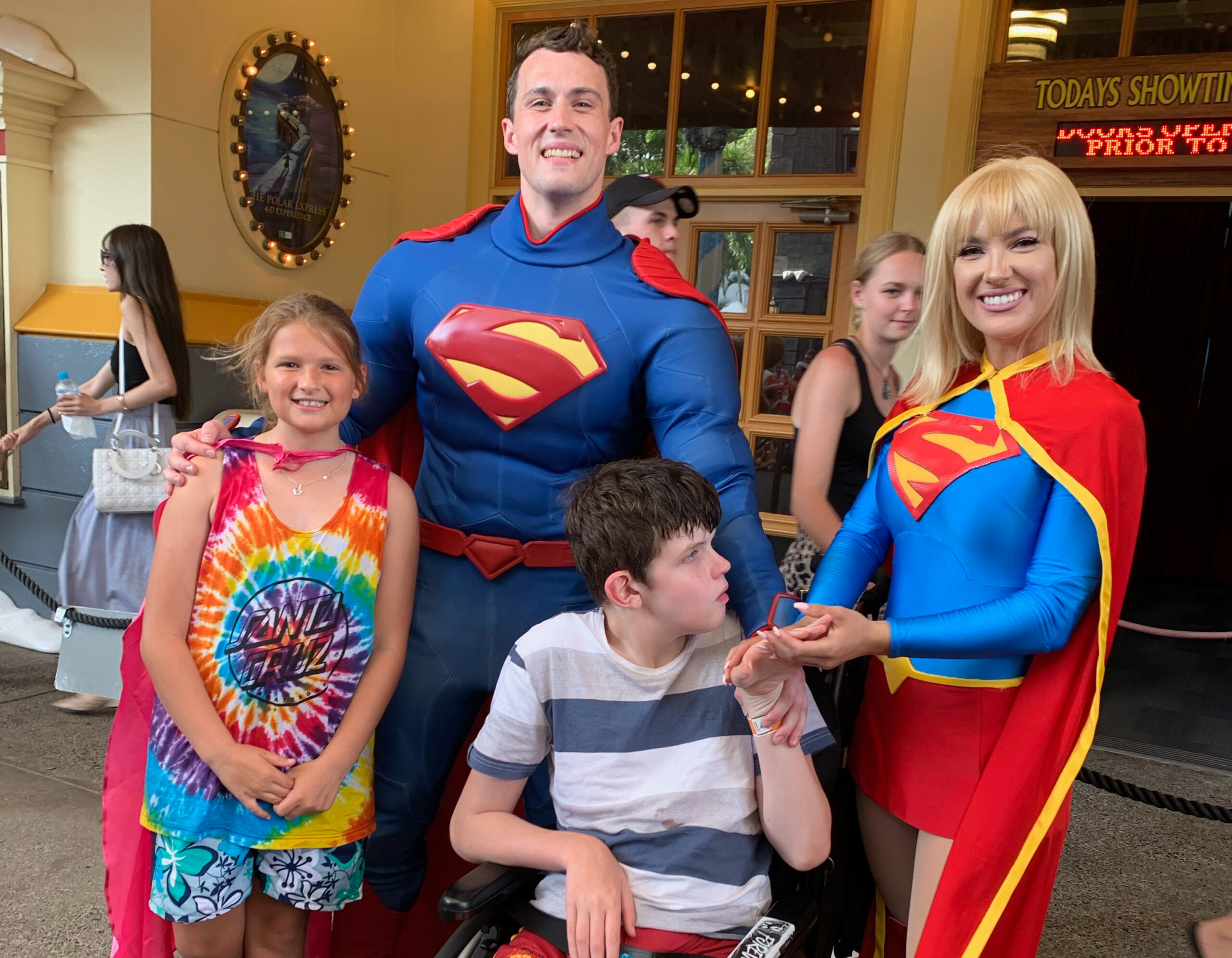 Two children with Superman and Supergirl