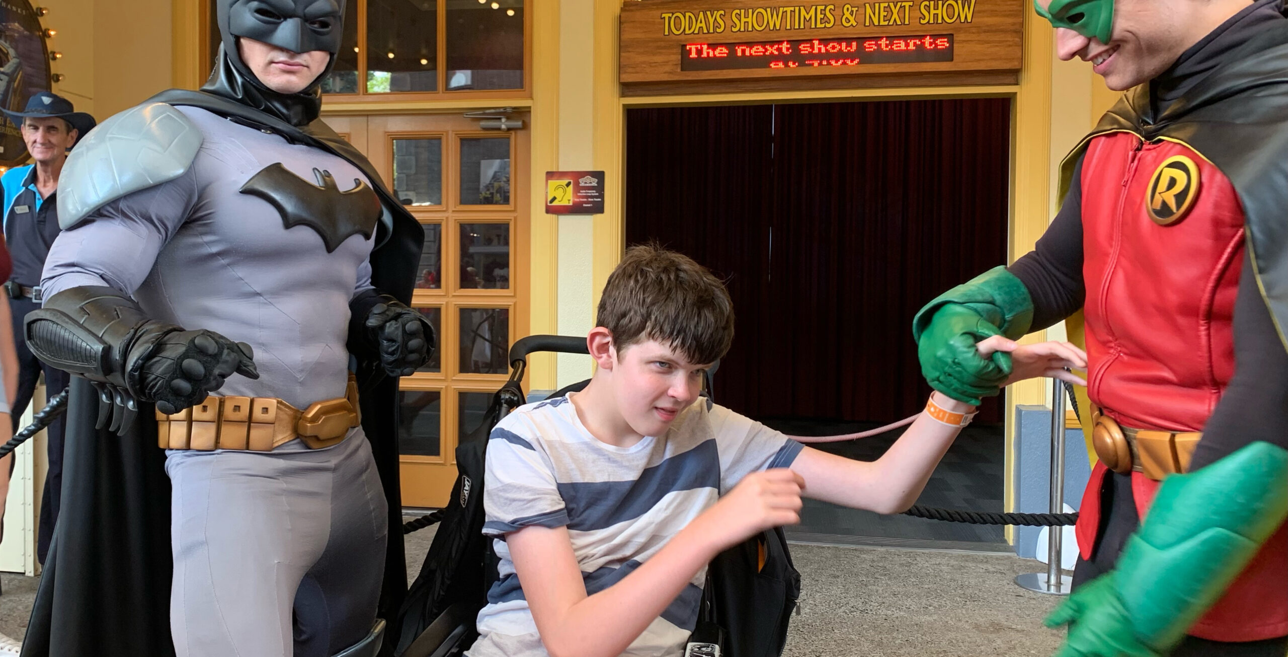 A boy meeting Batman and Robin at Movieworld